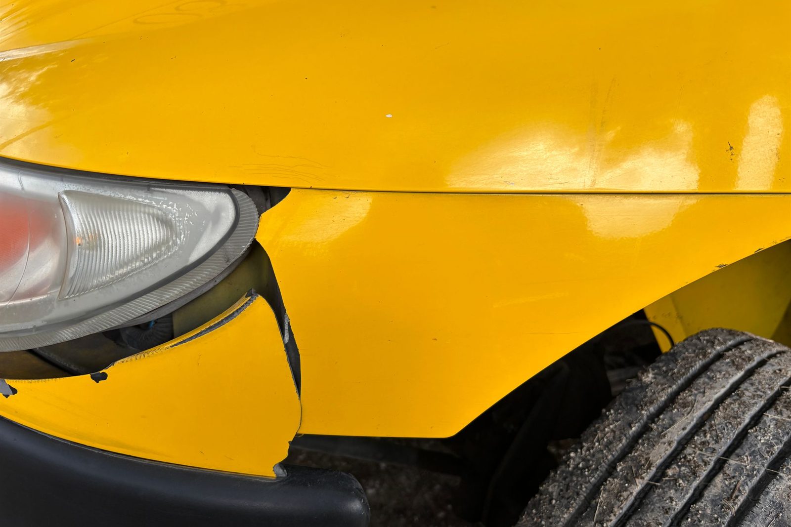 Close-up of damaged bodywork on a car wing
