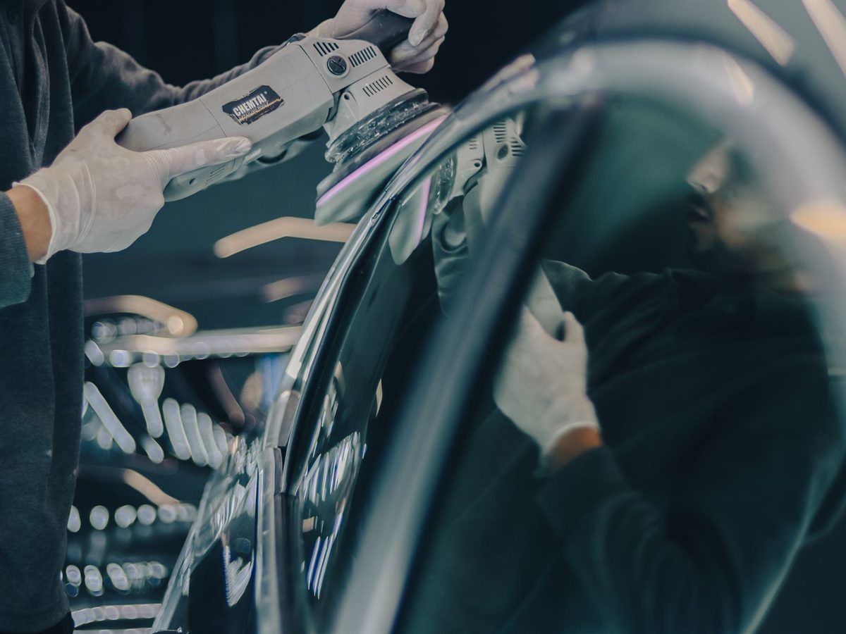 Technician working a dent out of a car body panel