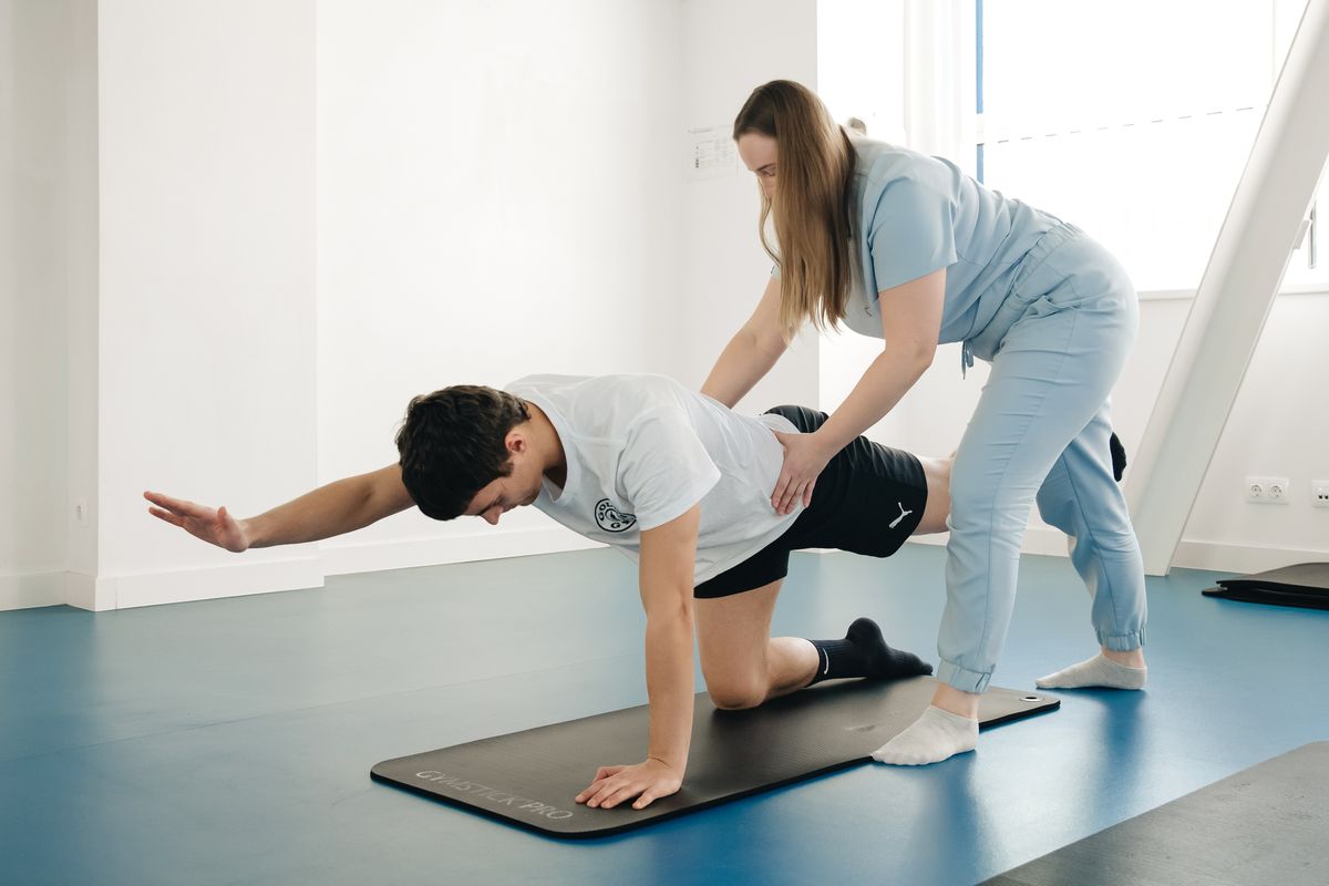 Biokineticist guiding a patient through a supervised exercise