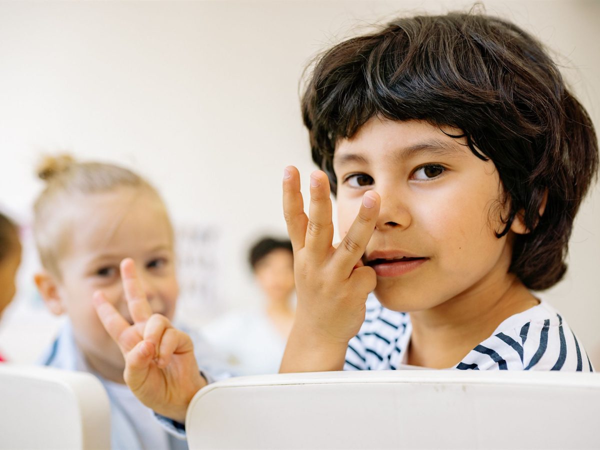 Two children counting together on their fingers in class
