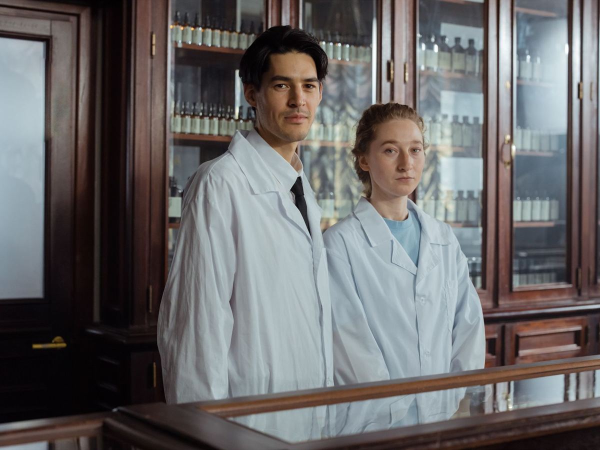 Two pharmacists working together behind the dispensary counter