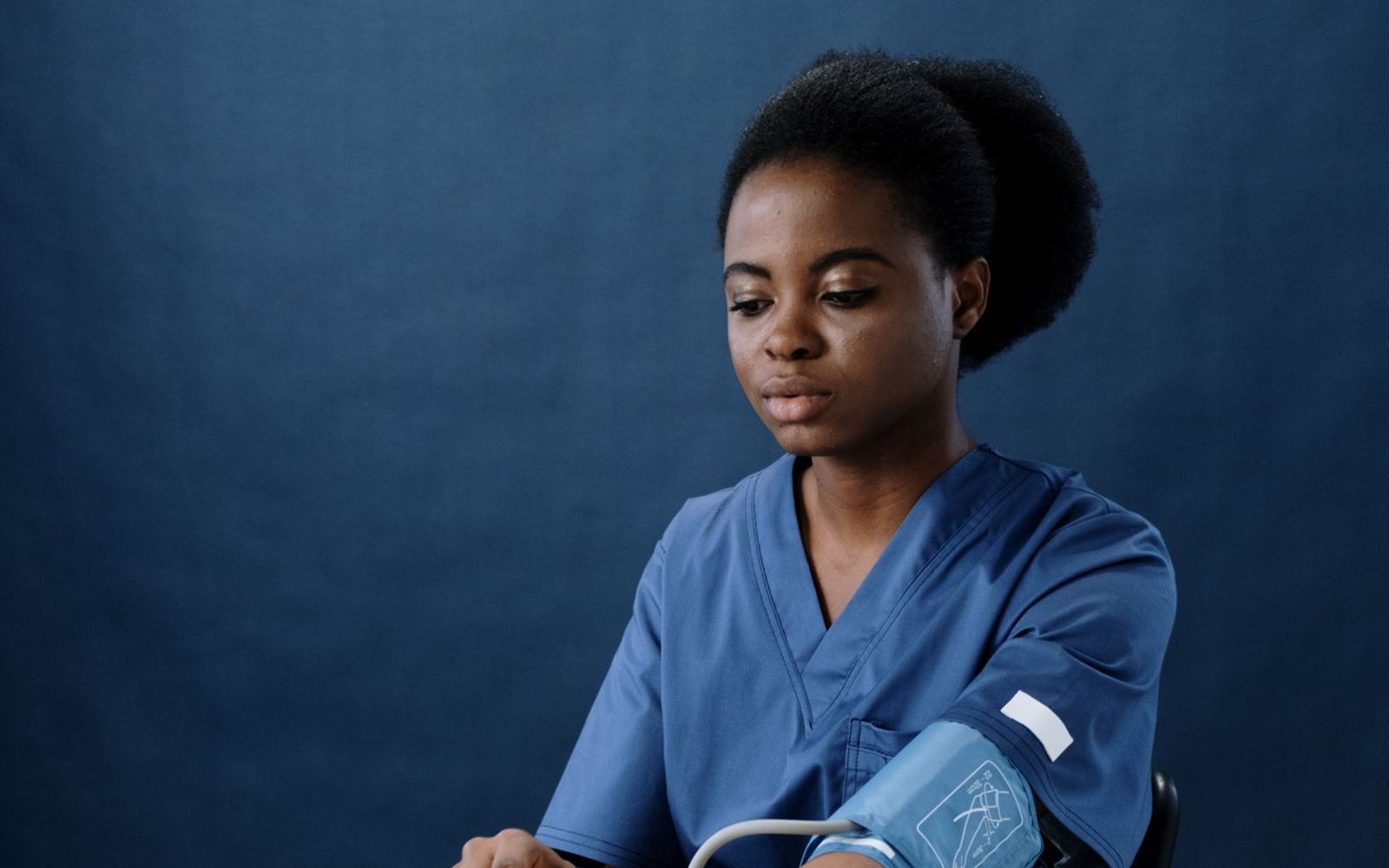 A nursing sister taking a patient's blood pressure in a clinic