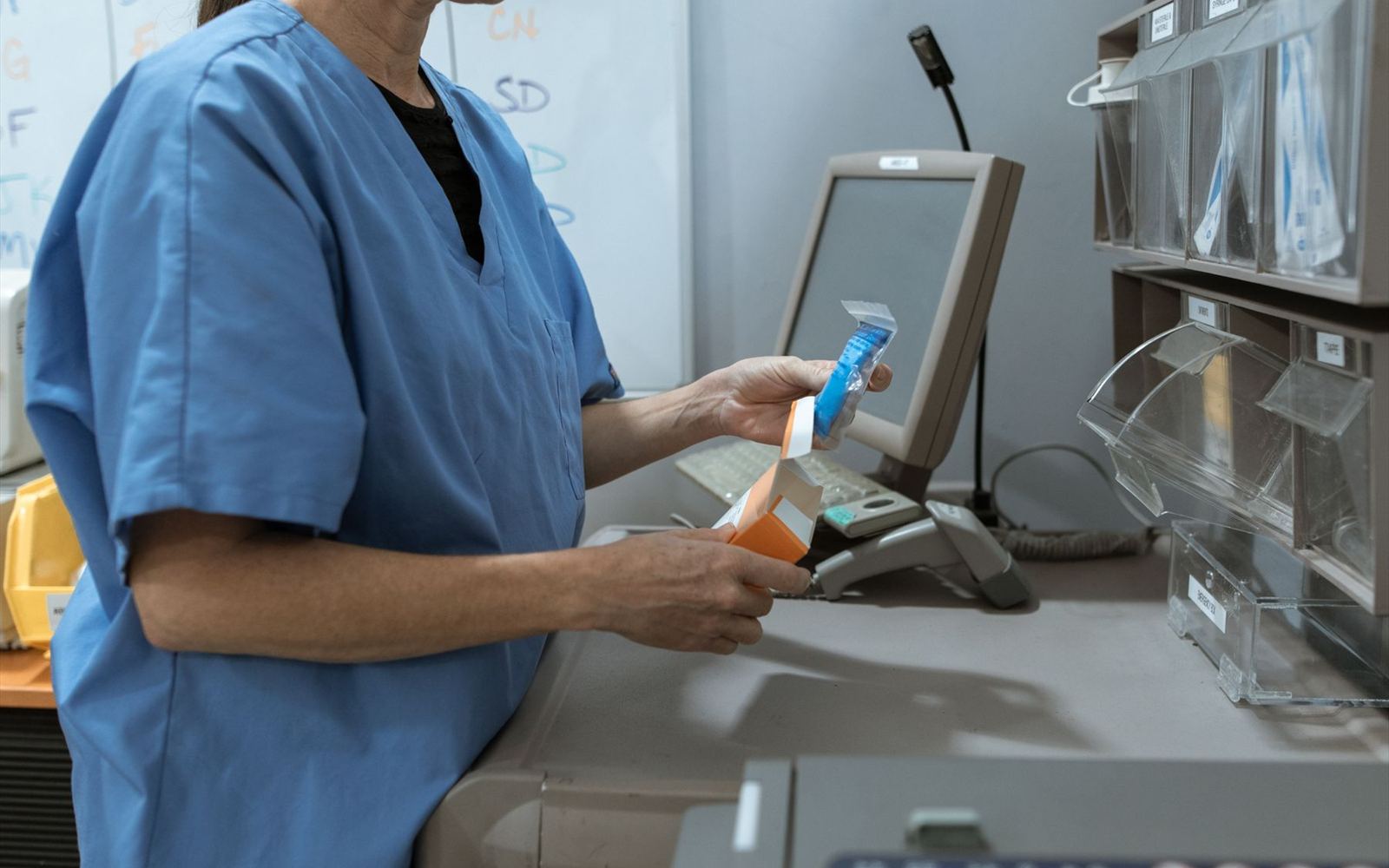 Hands packing out medicine at a dispensary counter