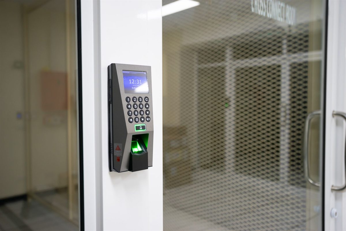 Fingerprint access control reader beside a glass door