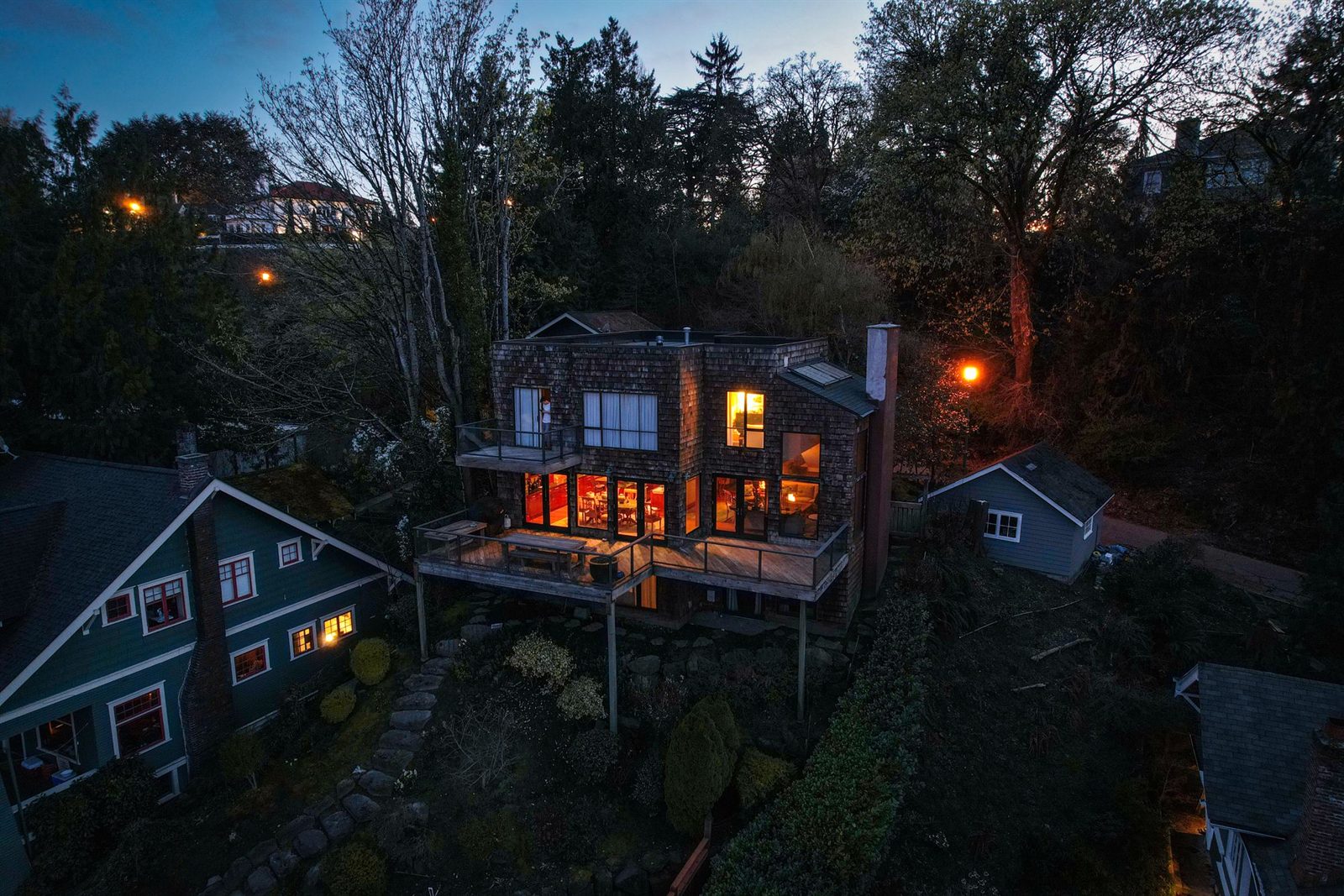 A house lit up at night among trees