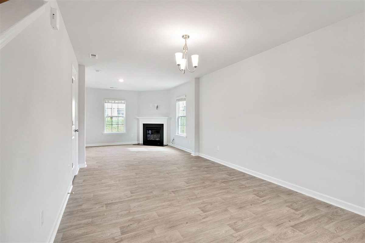 Freshly painted living room with white walls and pale oak flooring