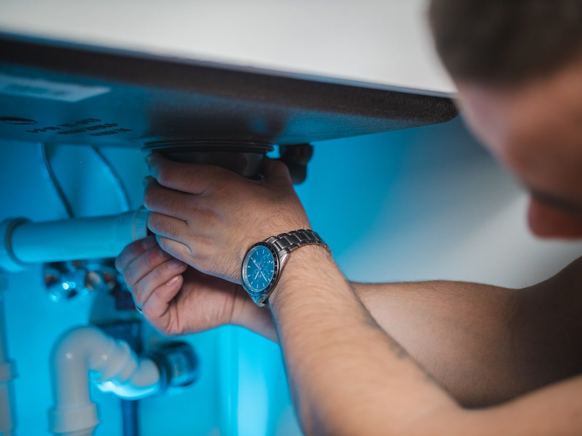 Close-up of hands tightening a basin waste pipe