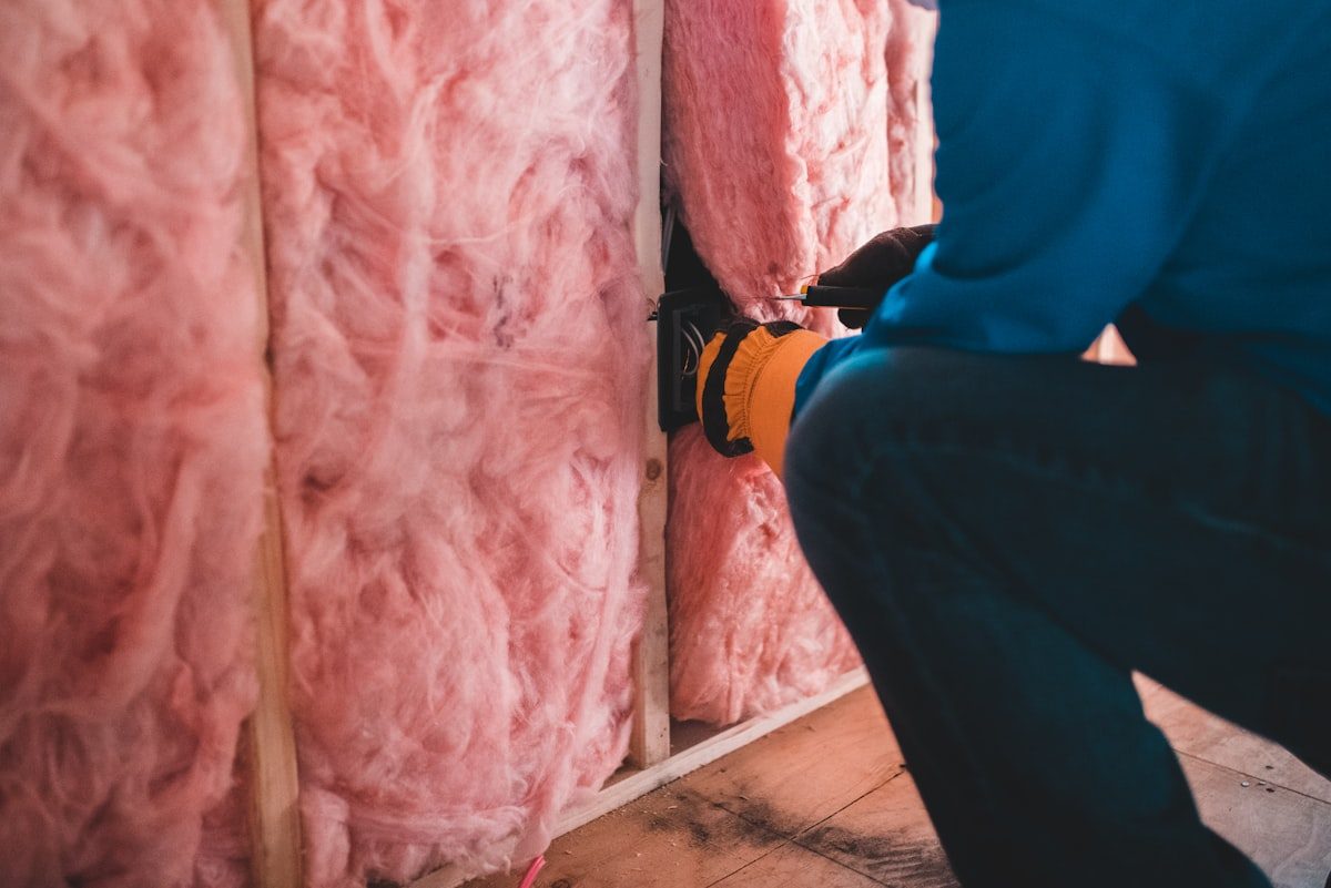 Insulation being fitted between timber studs to improve efficiency