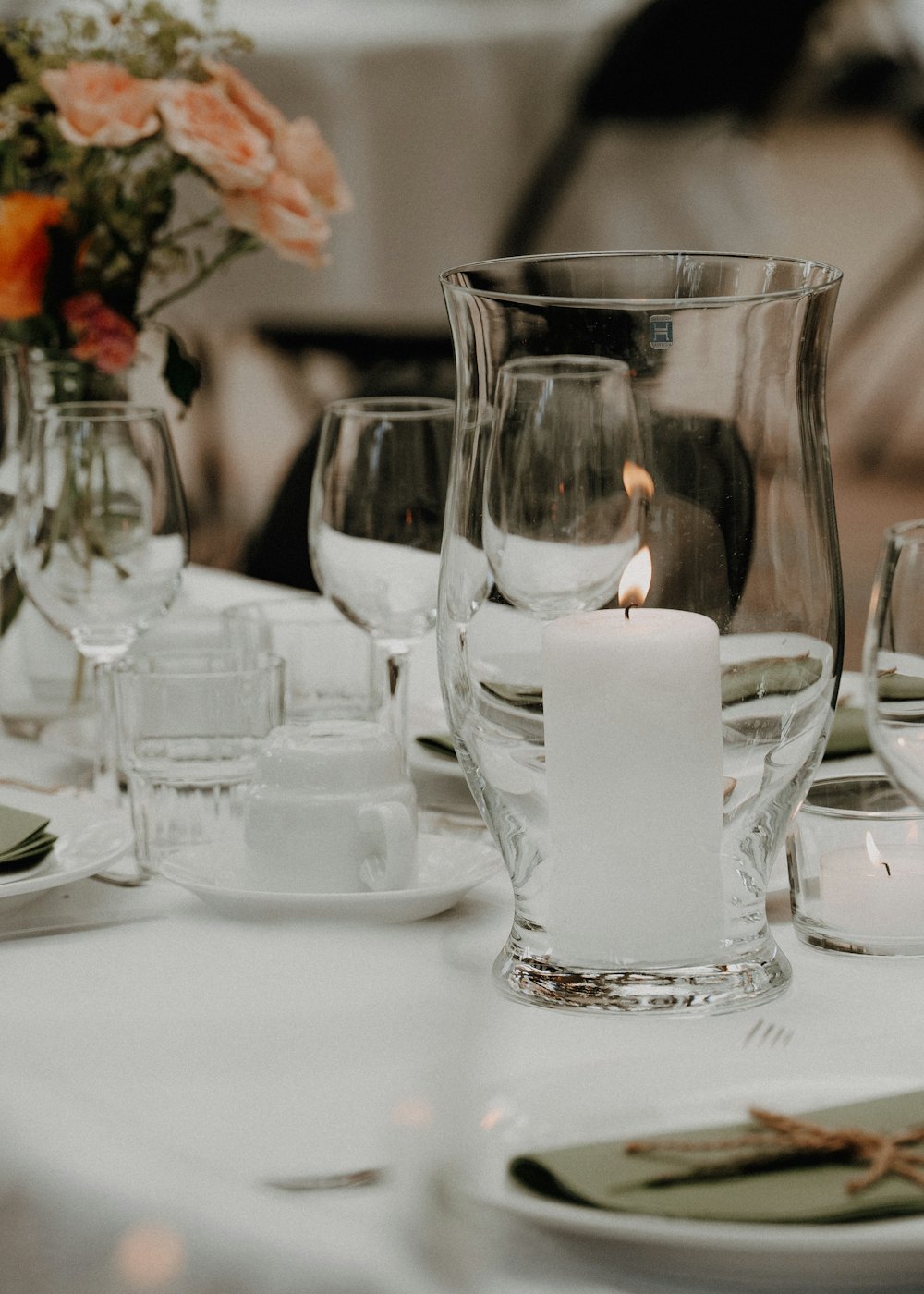 A table setting with a lit candle and flowers
