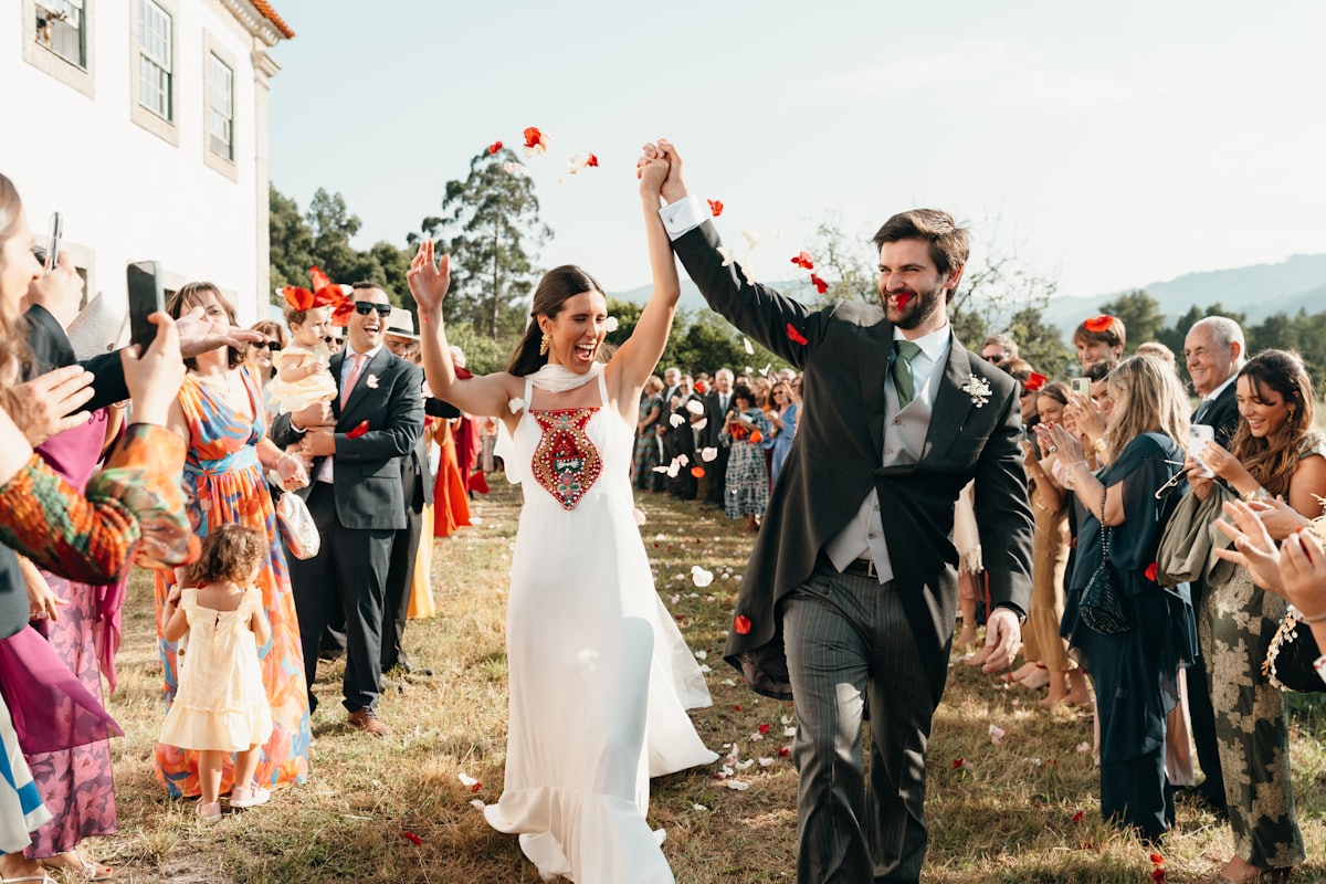 A newly married couple walking through a shower of petals