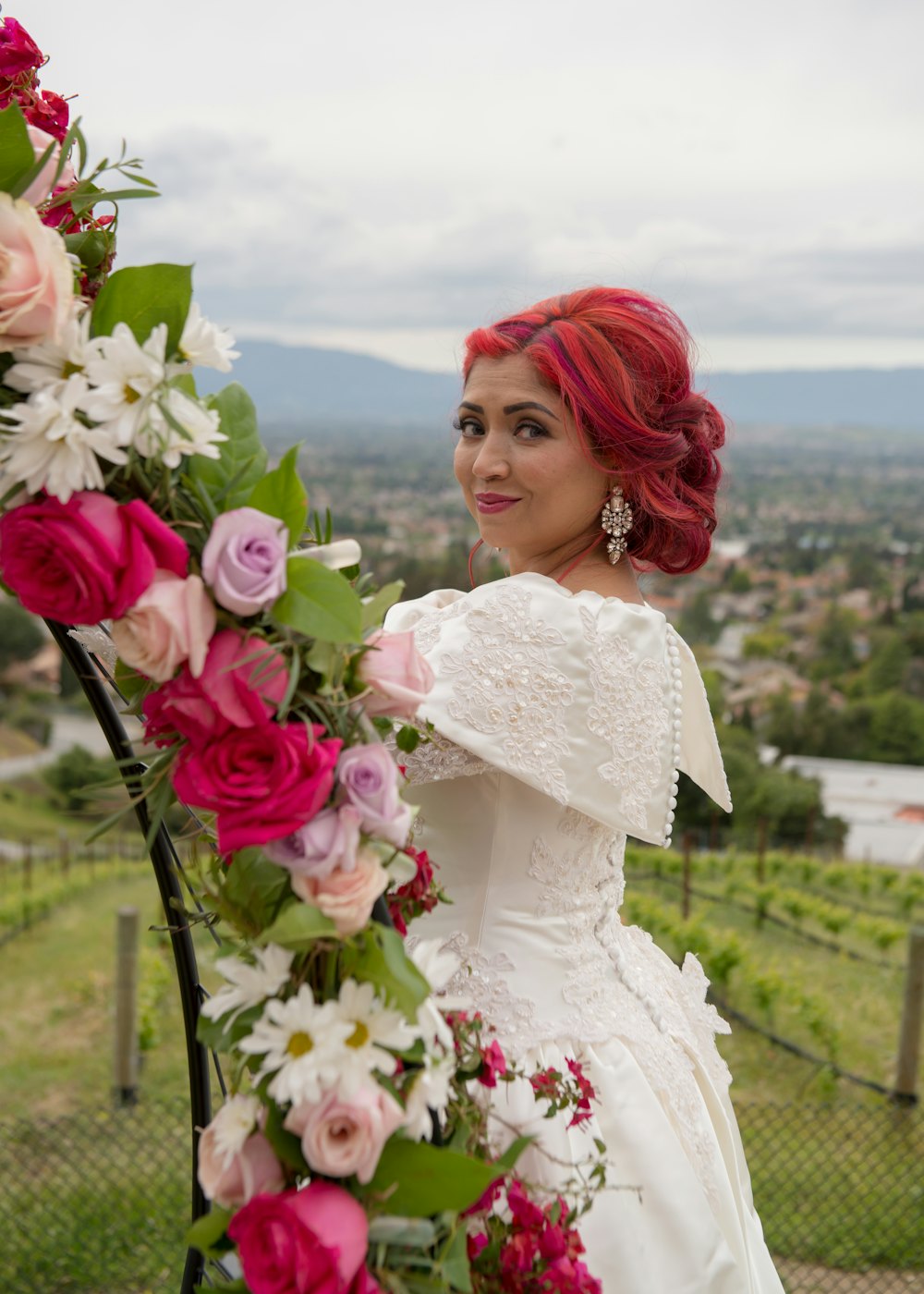 A bride standing beside a floral arch