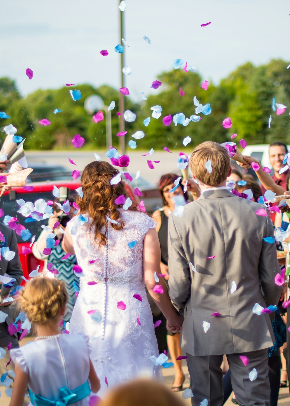 A newly married couple surrounded by guests throwing confetti