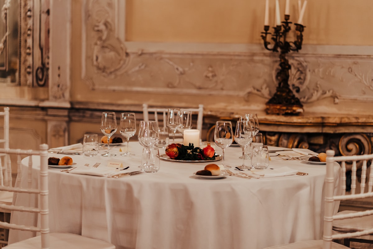 A white tablecloth laid with plates and glasses