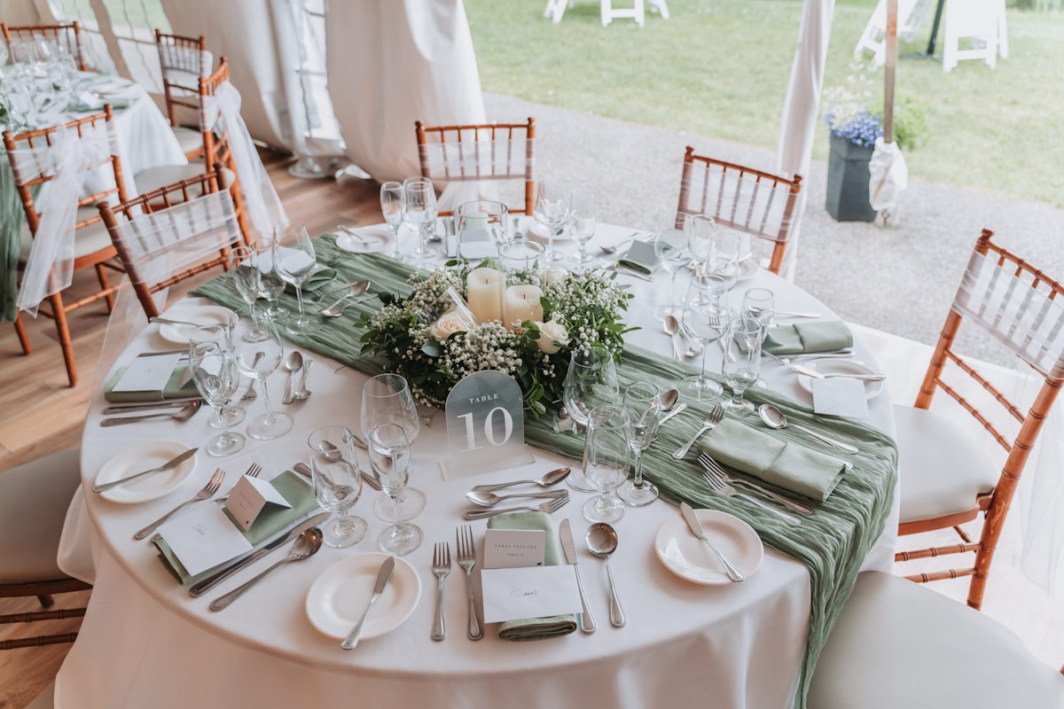 A round table set for a formal dinner with a floral centrepiece