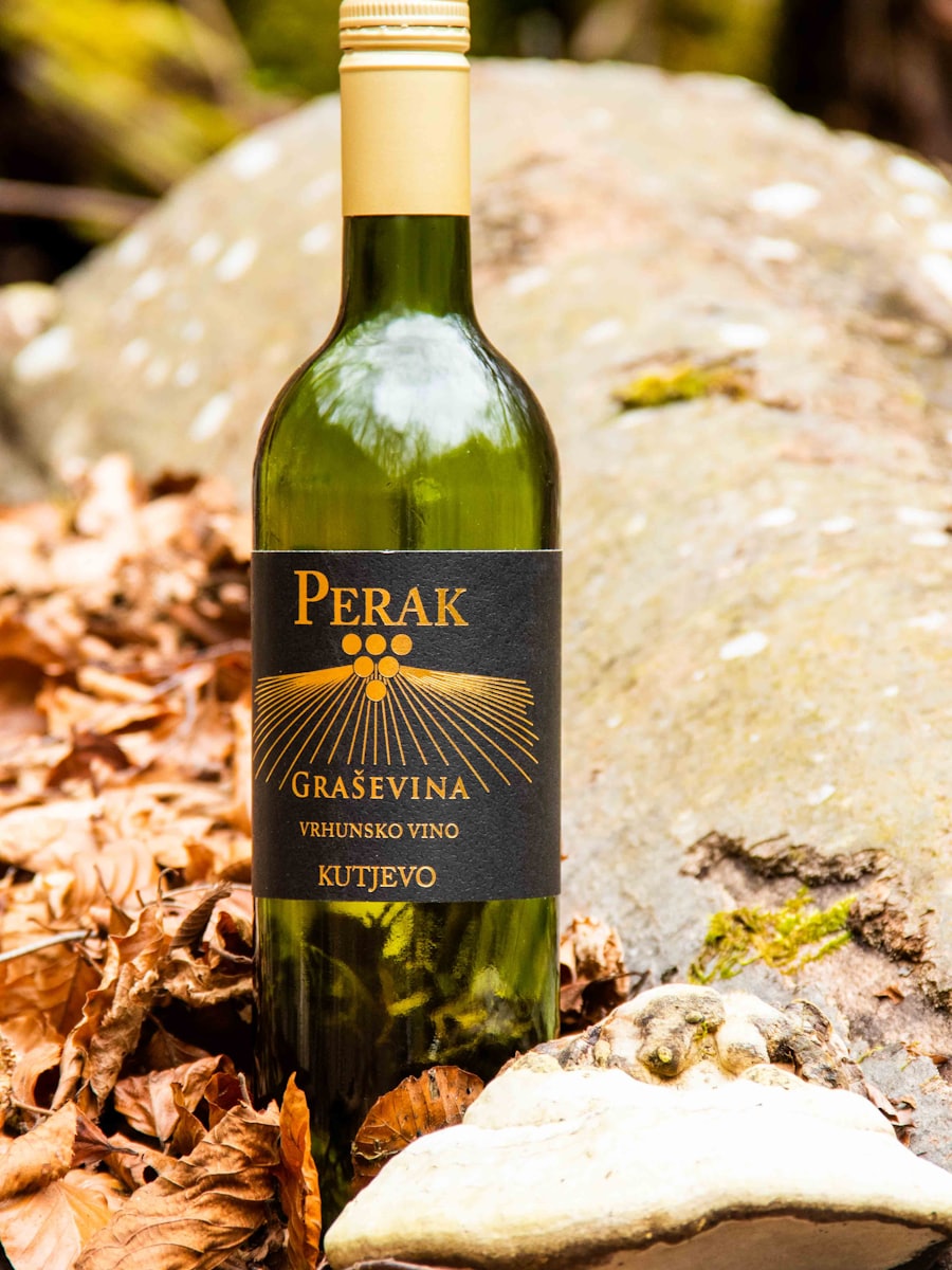 A bottle of wine lying on a bed of autumn leaves