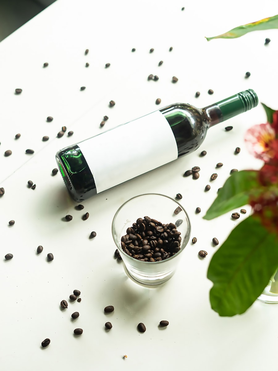 A bottle standing beside a bowl of coffee beans